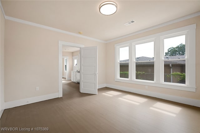 spare room featuring dark wood-type flooring and ornamental molding