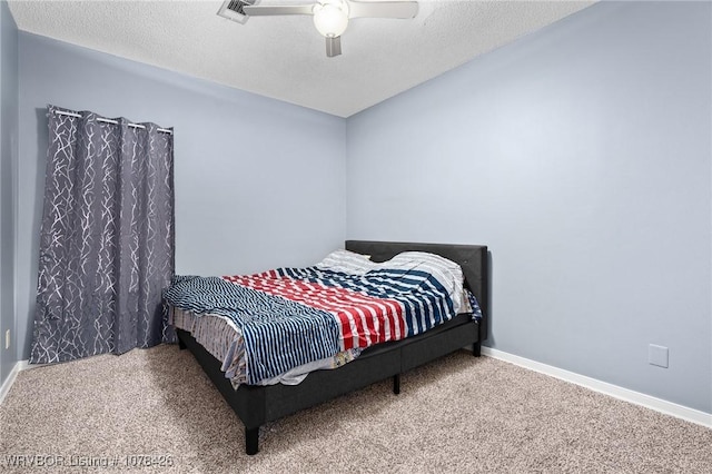 carpeted bedroom featuring ceiling fan and a textured ceiling