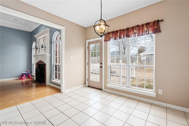 interior space featuring an inviting chandelier, light tile patterned floors, and ornamental molding