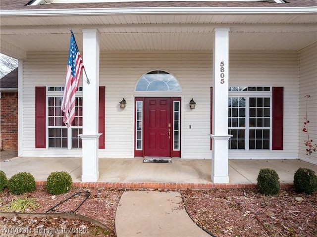 view of exterior entry featuring covered porch