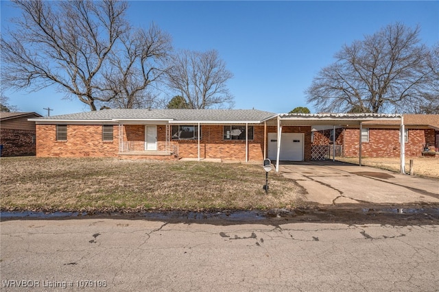 single story home with a garage, driveway, a front yard, a carport, and brick siding