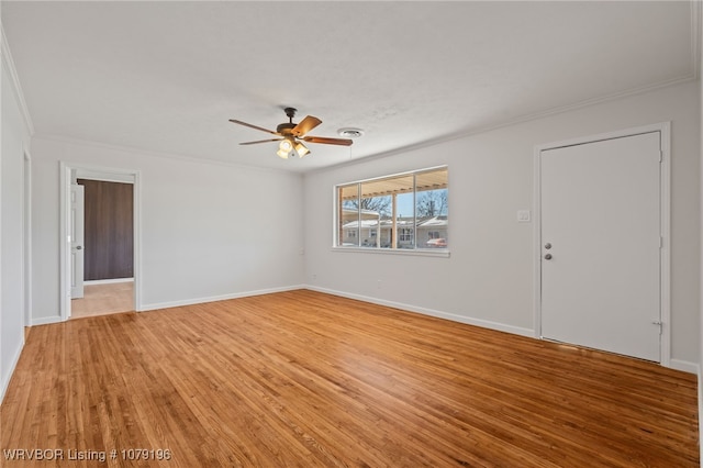 interior space featuring ornamental molding, baseboards, ceiling fan, and light wood finished floors