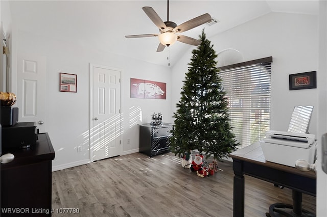 home office featuring ceiling fan, light hardwood / wood-style floors, and lofted ceiling