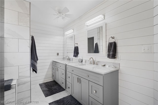 bathroom featuring vanity, wood walls, and ceiling fan