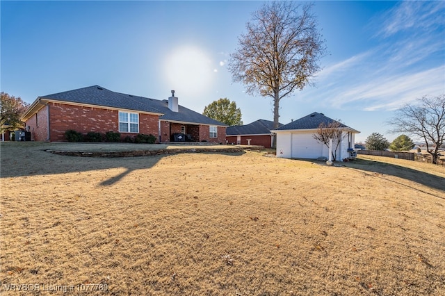 back of property featuring a garage and a yard