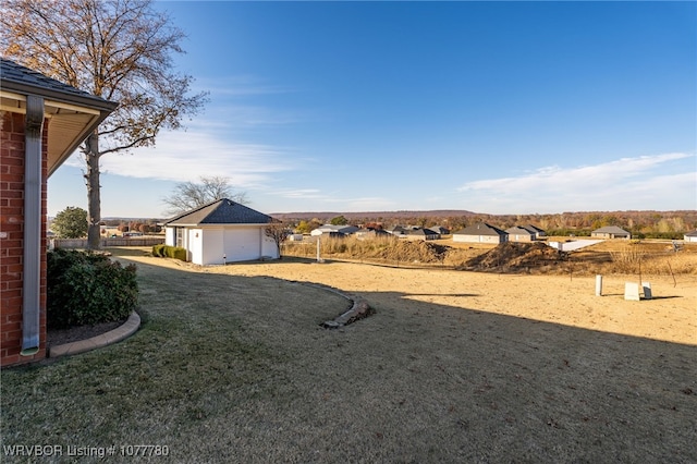 view of yard with a garage and an outbuilding