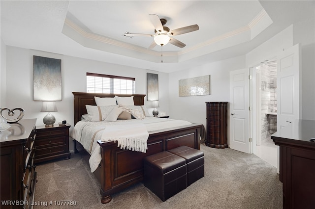 bedroom with carpet flooring, ceiling fan, a raised ceiling, and connected bathroom