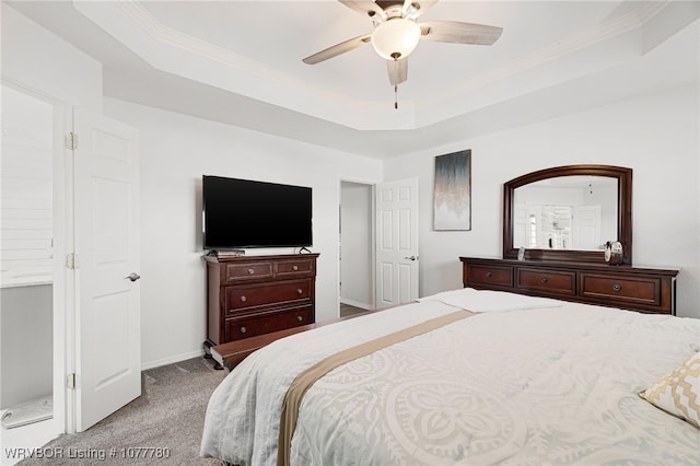 carpeted bedroom with a tray ceiling, ceiling fan, and crown molding