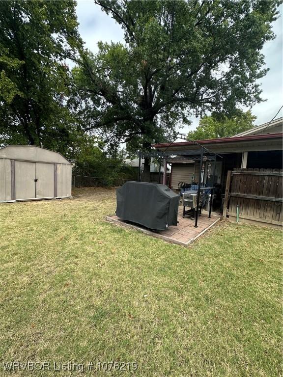 view of yard with a shed and a patio area