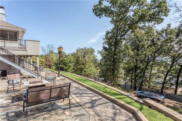 view of patio / terrace featuring a trampoline and a fire pit