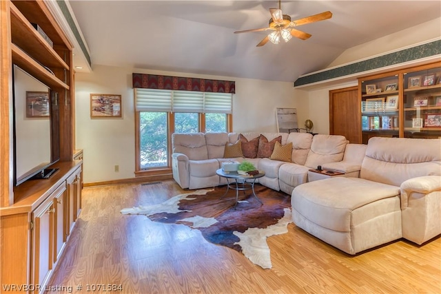 living room featuring ceiling fan, light hardwood / wood-style floors, and lofted ceiling