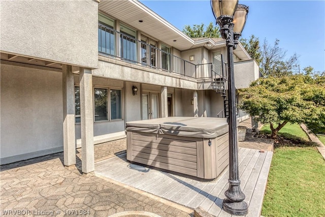 view of patio / terrace with a balcony and a hot tub