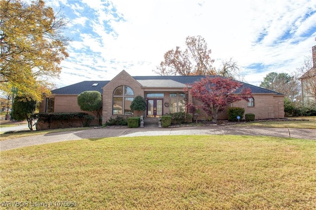 view of front facade with a front yard and french doors