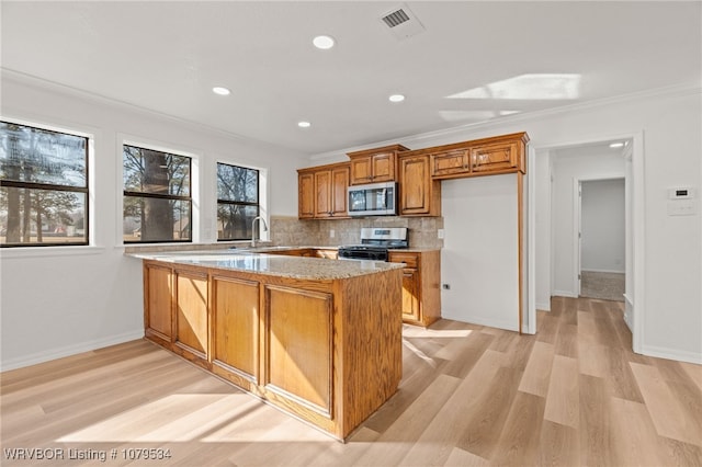 kitchen with ornamental molding, decorative backsplash, light wood-style floors, brown cabinetry, and stainless steel appliances