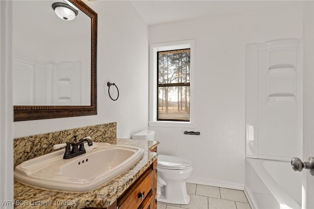 bathroom featuring baseboards, toilet, vanity, and tile patterned flooring