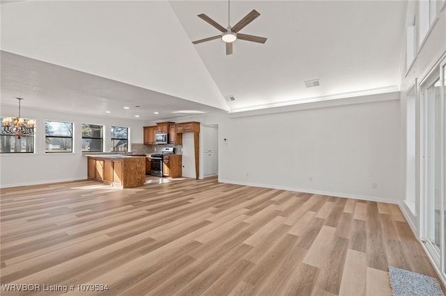 unfurnished living room featuring visible vents, high vaulted ceiling, light wood-style flooring, and ceiling fan with notable chandelier