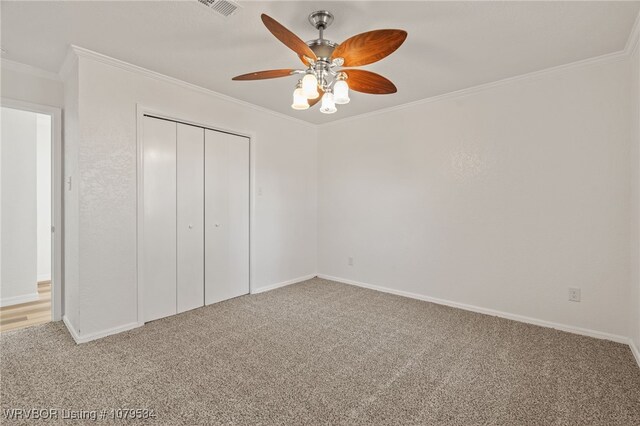 unfurnished bedroom with a closet, a ceiling fan, ornamental molding, and carpet flooring