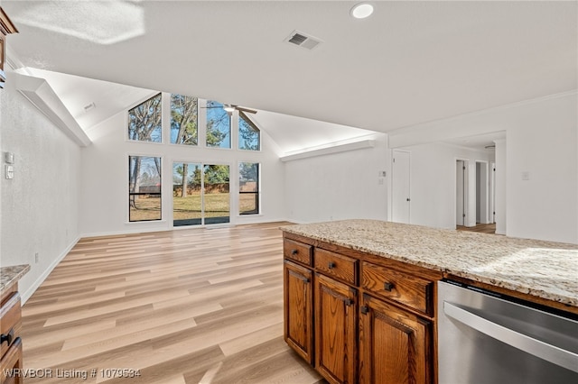 kitchen with a ceiling fan, light stone countertops, light wood-type flooring, vaulted ceiling, and open floor plan