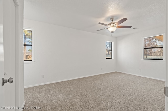 spare room featuring visible vents, a textured ceiling, ceiling fan, and carpet floors