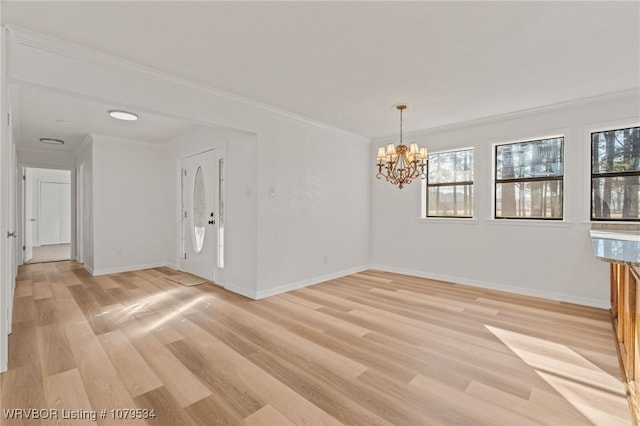 unfurnished room featuring baseboards, light wood-style floors, a chandelier, and ornamental molding