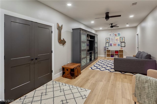 living room with hardwood / wood-style flooring and ceiling fan