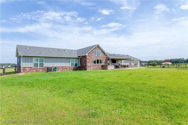 rear view of property featuring a lawn