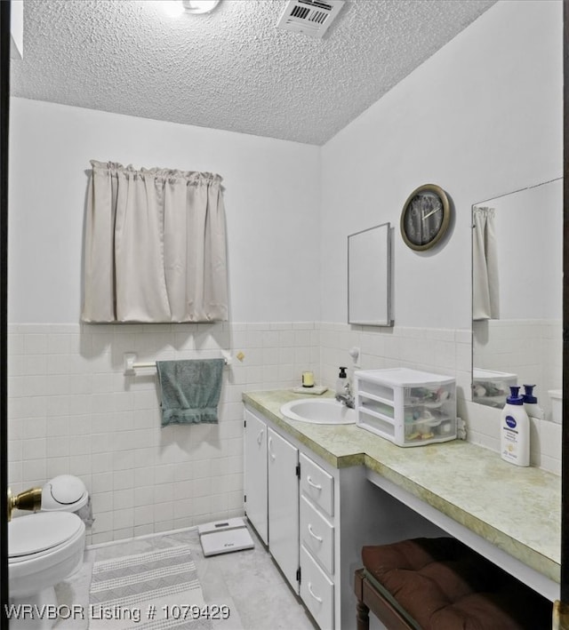 bathroom featuring visible vents, toilet, a textured ceiling, tile patterned flooring, and vanity