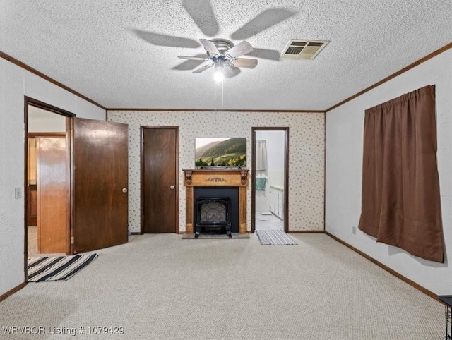 unfurnished living room with visible vents, a textured ceiling, wallpapered walls, and ornamental molding