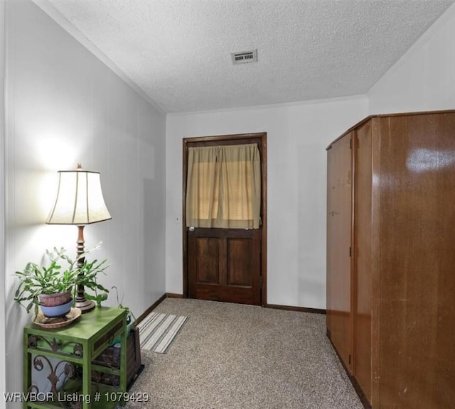 carpeted entrance foyer featuring baseboards, arched walkways, visible vents, and a textured ceiling