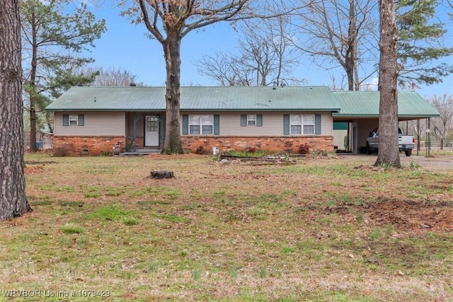 single story home with a carport, metal roof, a front yard, and brick siding