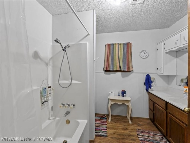 bathroom with shower / tub combination, wood finished floors, vanity, and a textured ceiling