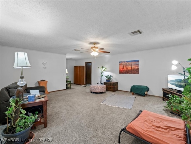 living room with carpet flooring, ceiling fan, a textured ceiling, and visible vents