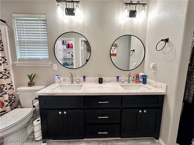 309 Arcadia Dr, Poteau, OK 74953 - full bathroom featuring double vanity, toilet, and wood finished floors