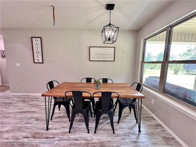 309 Arcadia Dr, Poteau, OK 74953 - dining area featuring light wood finished floors, a chandelier, baseboards, and a textured ceiling