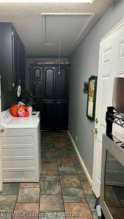 7434 N 217th Hwy, Charleston, AR 72933 - laundry area with washer / clothes dryer, cabinet space, stone tile floors, attic access, and a textured ceiling