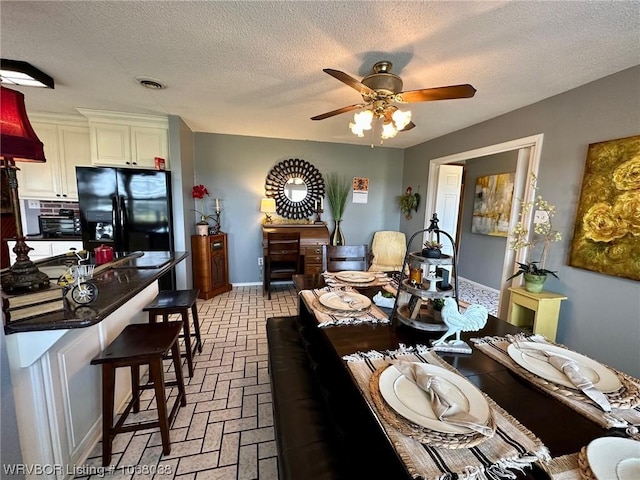 7434 N 217th Hwy, Charleston, AR 72933 - dining area with a ceiling fan, brick flooring, and a textured ceiling