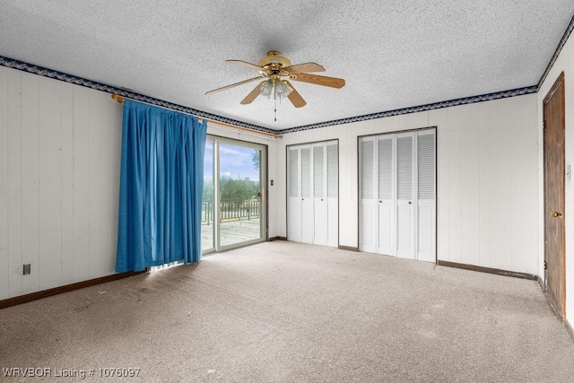 unfurnished bedroom featuring ceiling fan, access to exterior, carpet floors, and a textured ceiling