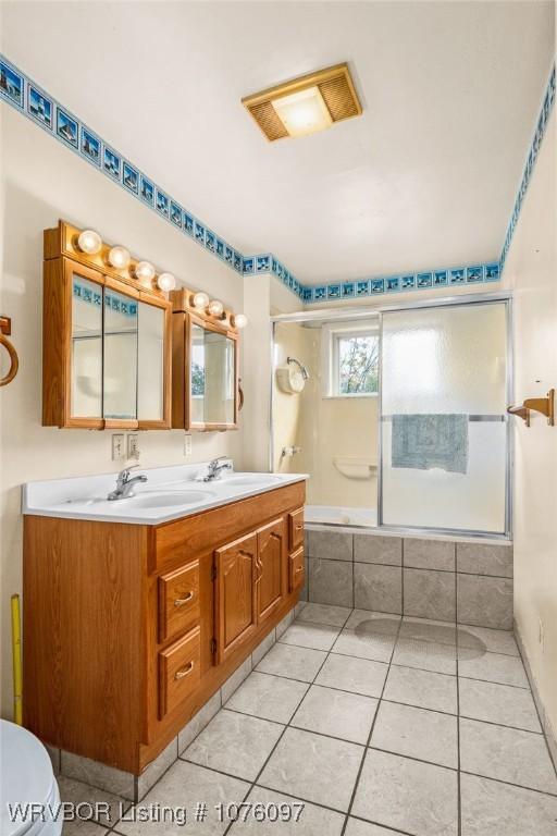 full bathroom with toilet, tile patterned flooring, vanity, and combined bath / shower with glass door