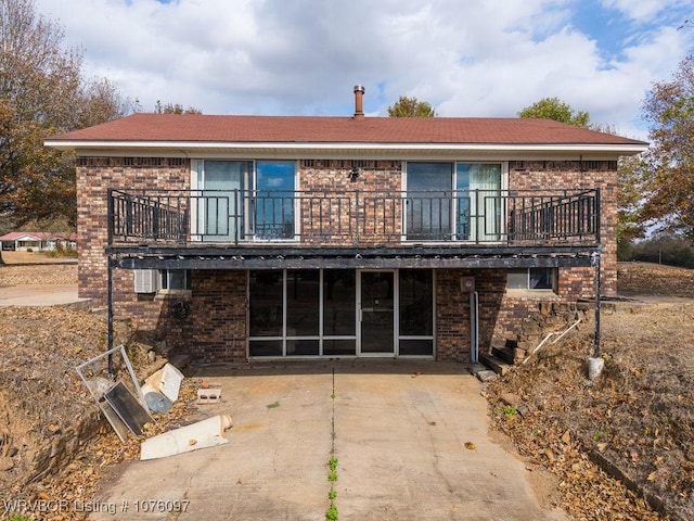 rear view of property featuring a balcony and a patio area