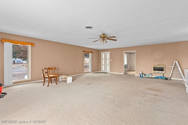 sitting room with carpet, heating unit, a wealth of natural light, and ceiling fan