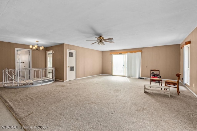 living room with carpet flooring and ceiling fan with notable chandelier