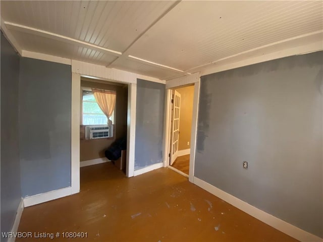 spare room with concrete floors, cooling unit, and baseboards