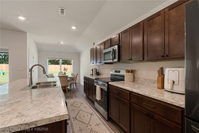 10618 Cedar Way, Fort Smith, AR 72916 - kitchen with appliances with stainless steel finishes, light countertops, light wood-style floors, lofted ceiling, and dark brown cabinets