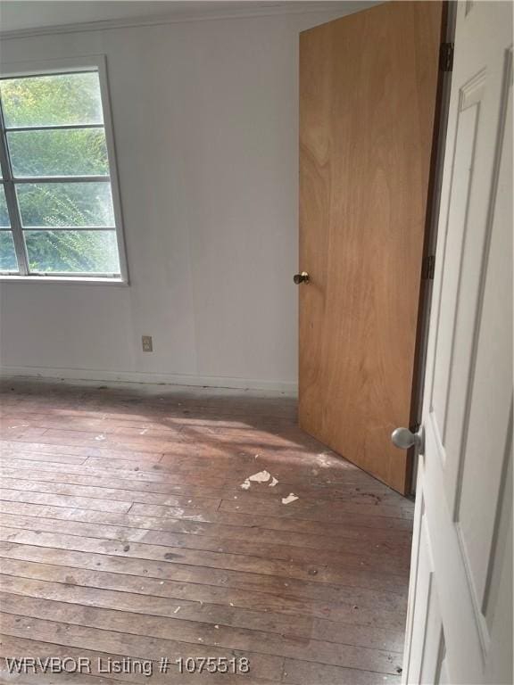 unfurnished bedroom featuring hardwood / wood-style flooring and ornamental molding