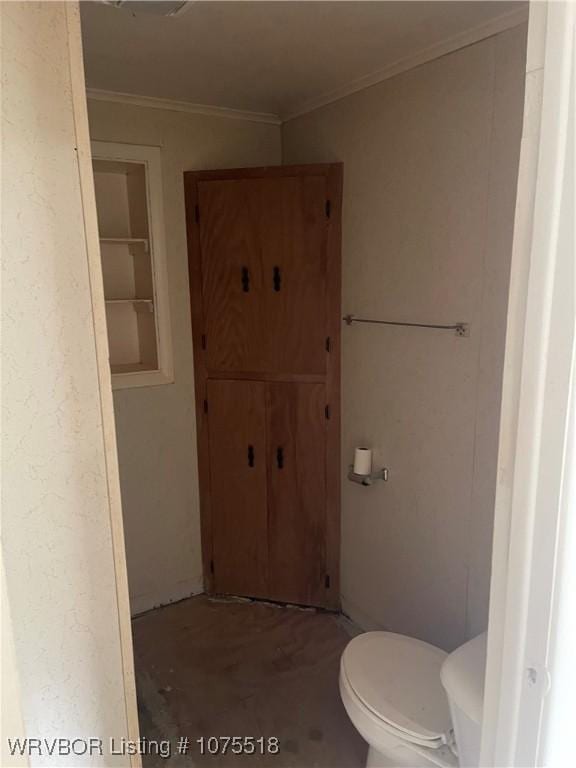 bathroom featuring built in shelves, toilet, concrete flooring, and crown molding