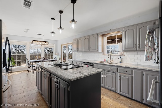 kitchen with gray cabinetry, a sink, stainless steel refrigerator with ice dispenser, dishwasher, and black electric stovetop