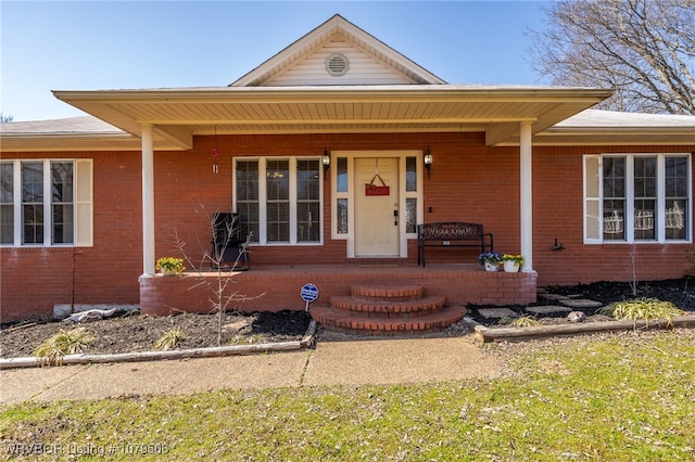 view of front of property featuring brick siding and covered porch