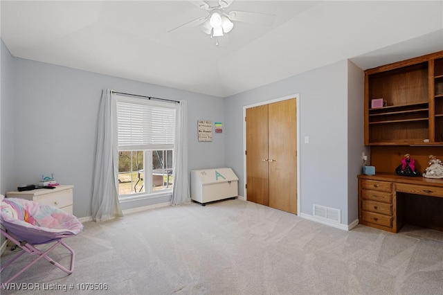 interior space with visible vents, baseboards, ceiling fan, light colored carpet, and lofted ceiling