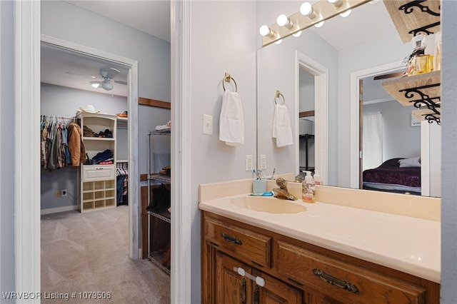 bathroom featuring a spacious closet and vanity