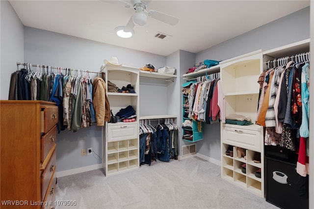 walk in closet featuring visible vents, light colored carpet, and ceiling fan